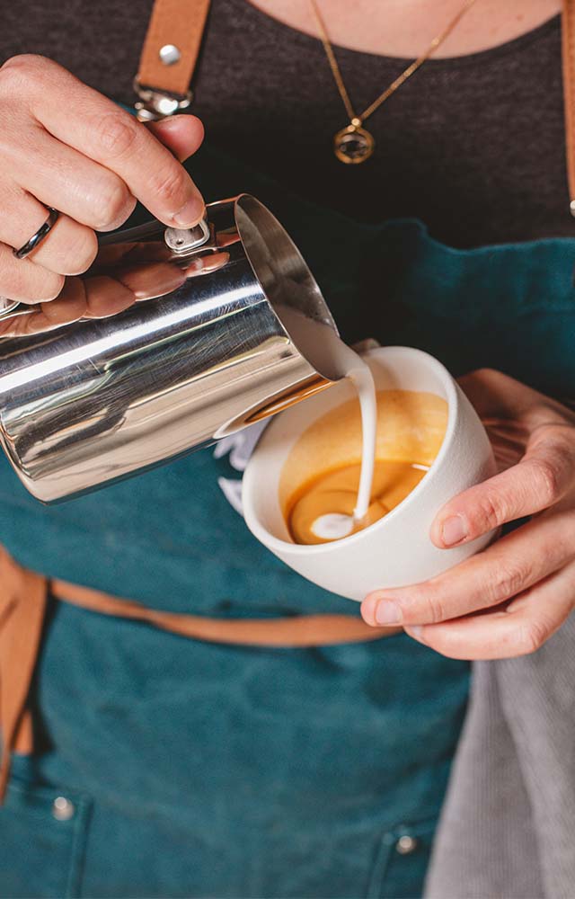 le barista utilise une machine à café pour mélanger le lait frais dans la  mousse pour faire un cappuccino ou un latte dans un café 10148228 Photo de  stock chez Vecteezy
